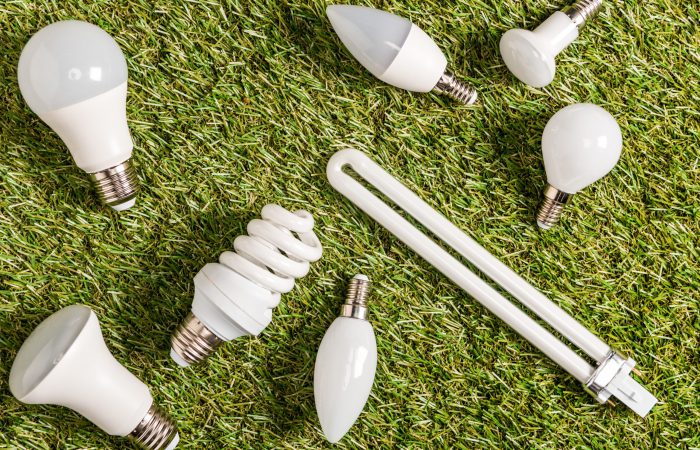 top view of fluorescent lamps on green grass, energy efficiency concept